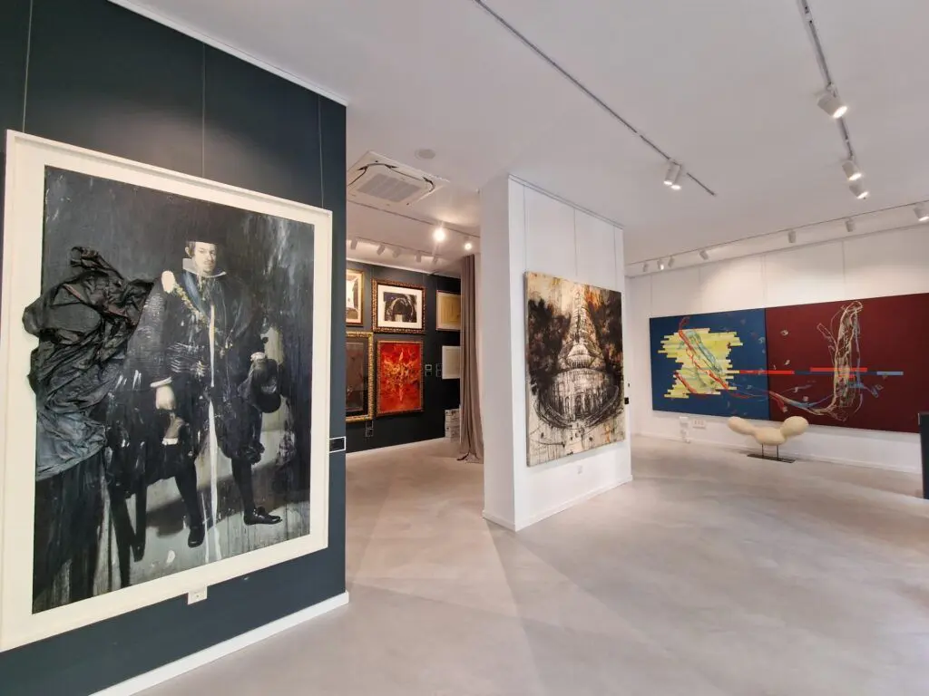 Perspectiva interior de la galería de arte Ojos del Barroco con diferentes salas de exposición que muestran pinturas contemporáneas y cuadros de gran formato.